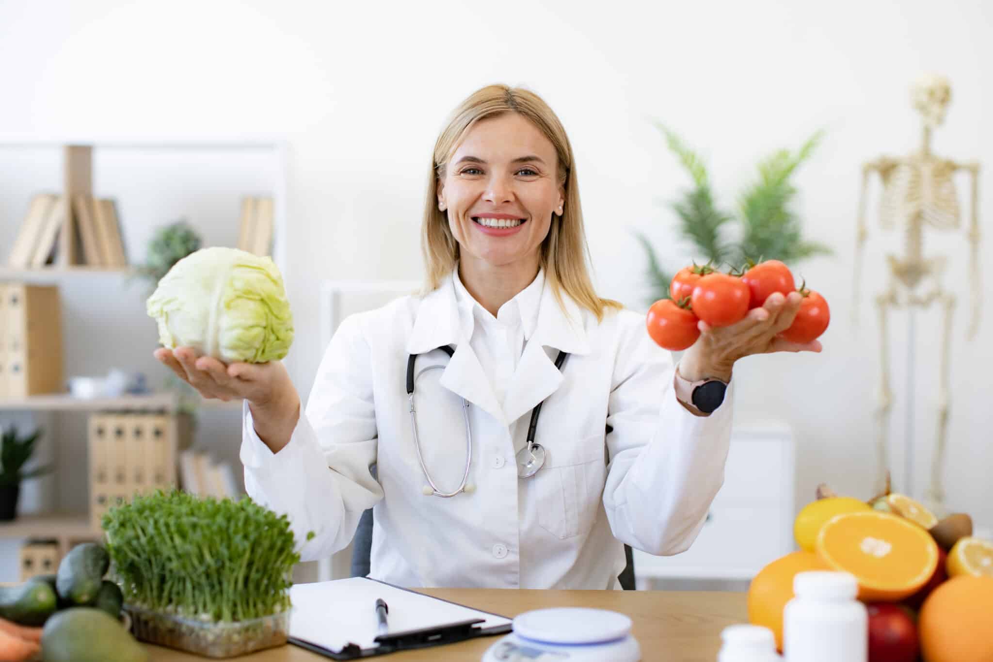 Spezialisierungen als Ernährungsberater - Der Weg zum Experten - Ernährungsberaterin hält frisches Gemüse und Obst in die Kamera