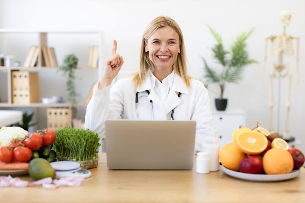 Spezialisierungen als Ernährungsberater - Die Trends 2025 - Ernährungsberaterin arbeitet mit Laptop und Computer