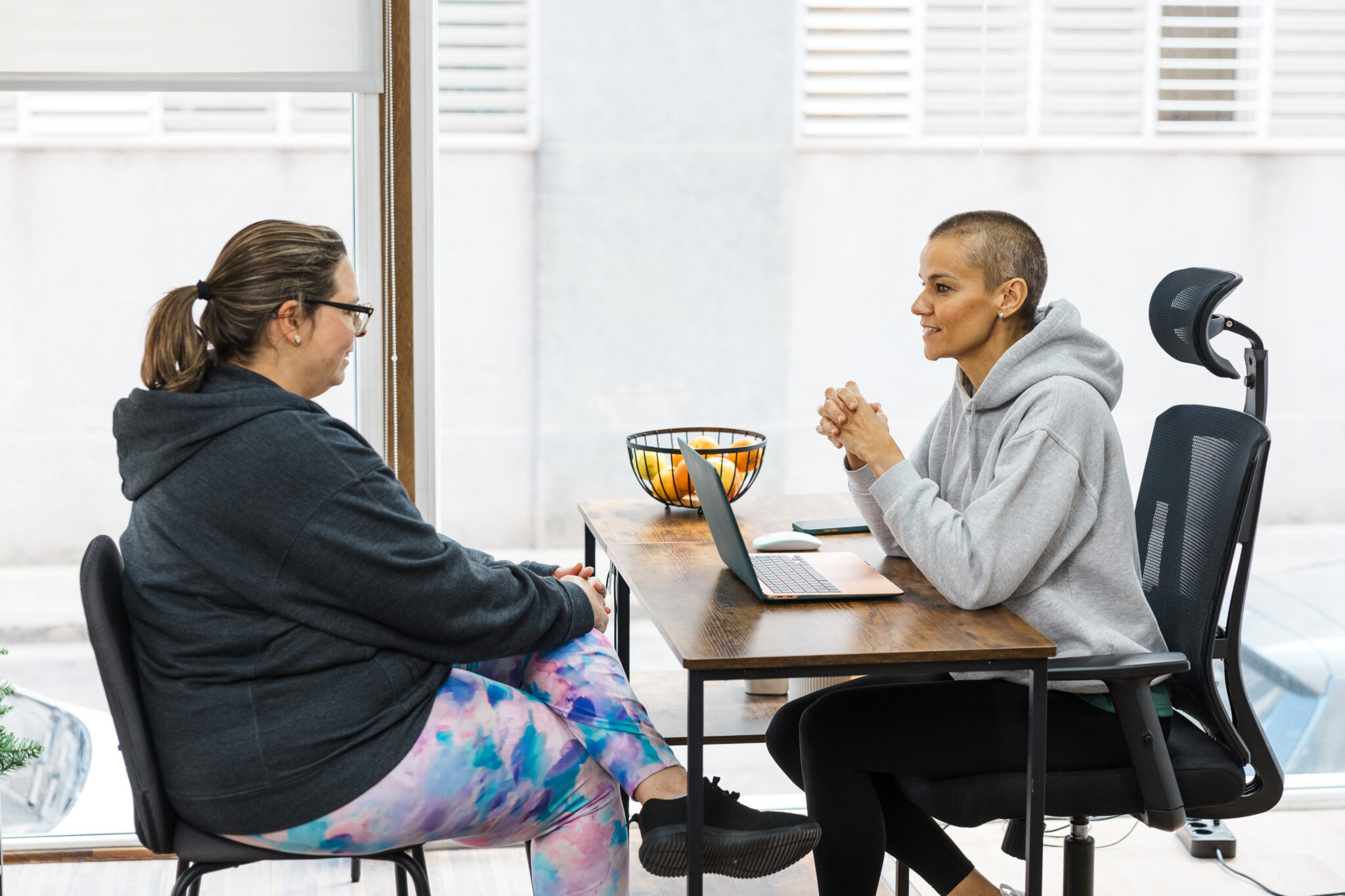 Ernährungsberaterin gibt einer Klientin am Schreibtisch in einem persönlichen 1zu1 Gespräch Infos zu ihrer Ernährung